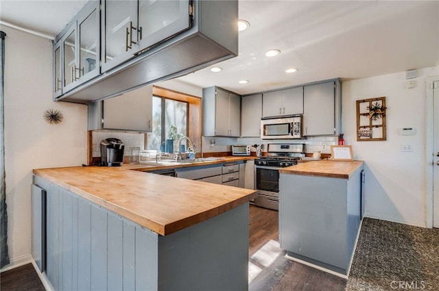 25389 Oak Glen Rd, Twin Peaks, CA 92391 - kitchen featuring appliances with stainless steel finishes, wood counters, gray cabinetry, a peninsula, and decorative backsplash
