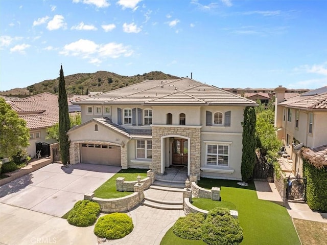 20342 Via Cellini, Porter Ranch, CA 91326 - mediterranean / spanish house featuring stucco siding, concrete driveway, an attached garage, french doors, and a mountain view