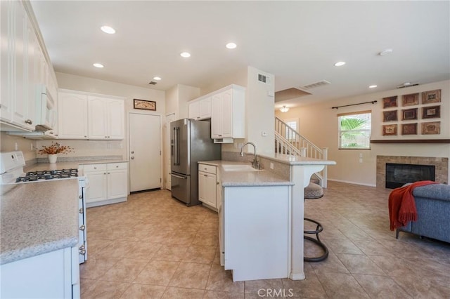 5681 Mapleview Dr, Jurupa Valley, CA 92509 - kitchen with a peninsula, white appliances, a kitchen breakfast bar, open floor plan, and white cabinetry