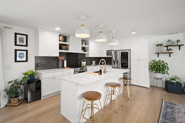 450 Pecan St, Arroyo Grande, CA 93420 - kitchen featuring open shelves, stainless steel appliances, tasteful backsplash, white cabinetry, and light wood-style flooring