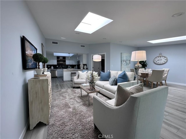 13361 El Dorado Unit 201K, Seal Beach, CA 90740 - living area with a skylight and light wood-style floors