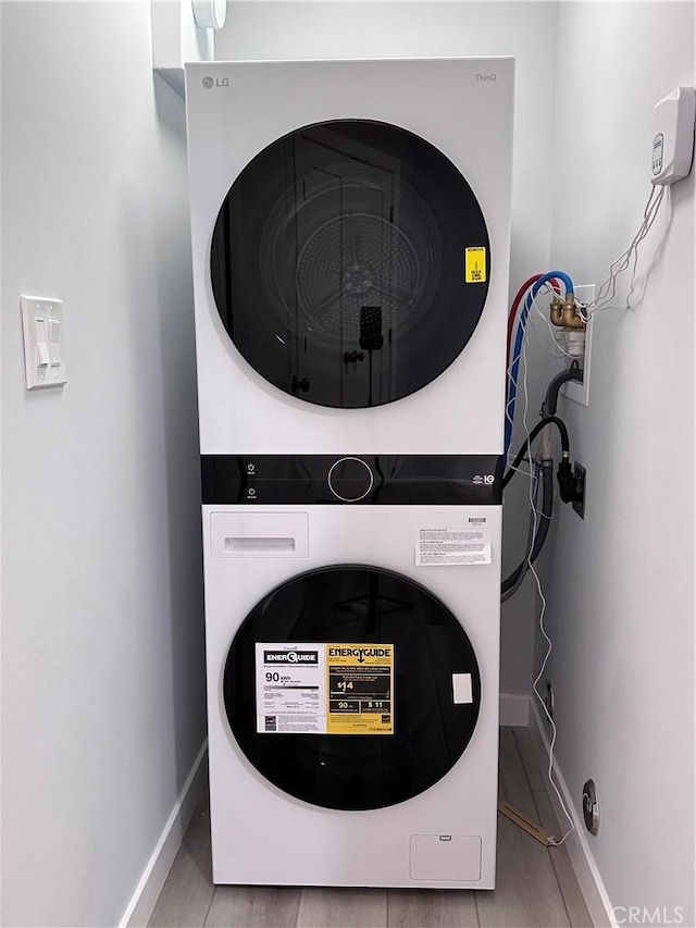 13361 El Dorado Unit 201K, Seal Beach, CA 90740 - laundry room featuring stacked washer and clothes dryer and baseboards