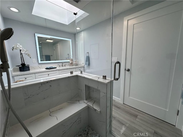 13361 El Dorado Unit 201K, Seal Beach, CA 90740 - bathroom with a skylight, wood finished floors, recessed lighting, vanity, and a shower with door