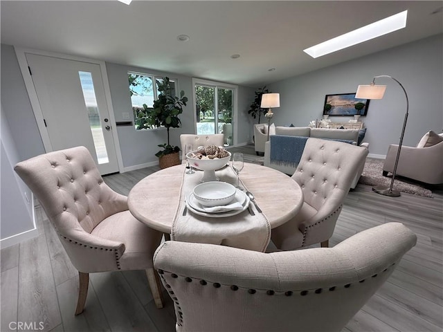 13361 El Dorado Unit 201K, Seal Beach, CA 90740 - dining space with a skylight, wood finished floors, and vaulted ceiling