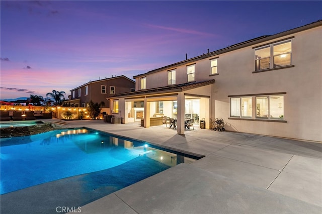 16671 Zest Ct, Riverside, CA 92503 - pool at dusk featuring a patio, a pool with connected hot tub, and outdoor dining space