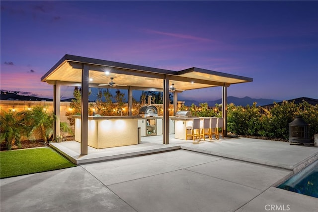 16671 Zest Ct, Riverside, CA 92503 - patio terrace at dusk with area for grilling, a patio, and a ceiling fan