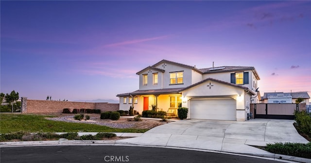 16671 Zest Ct, Riverside, CA 92503 - traditional-style home with driveway, roof mounted solar panels, stucco siding, a gate, and covered porch