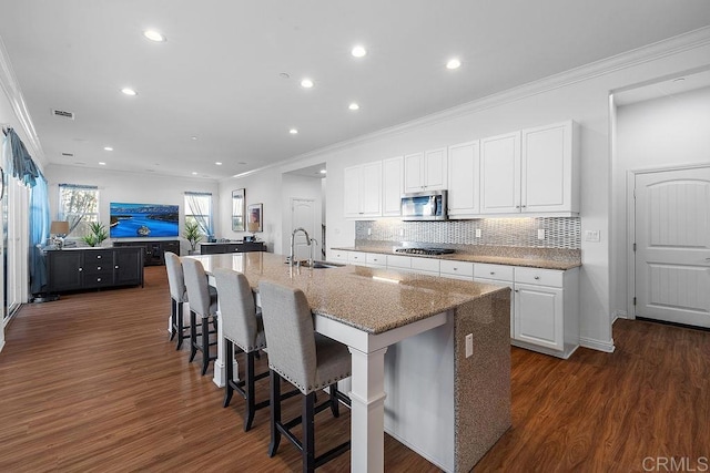 1837 Ashley Ave, Chula Vista, CA 91913 - kitchen featuring appliances with stainless steel finishes, crown molding, dark wood-style flooring, white cabinetry, and stone countertops