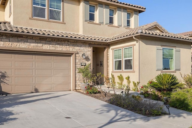 1837 Ashley Ave, Chula Vista, CA 91913 - mediterranean / spanish home with driveway, a tiled roof, stucco siding, stone siding, and an attached garage