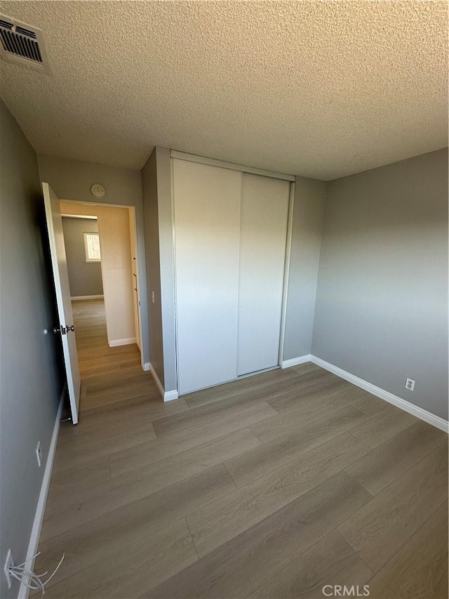 8567 Jasper St, Rancho Cucamonga, CA 91730 - unfurnished bedroom with wood finished floors, a textured ceiling, and a closet
