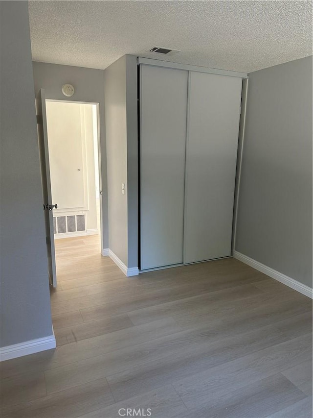 8567 Jasper St, Rancho Cucamonga, CA 91730 - unfurnished bedroom with a textured ceiling, wood finished floors, and a closet