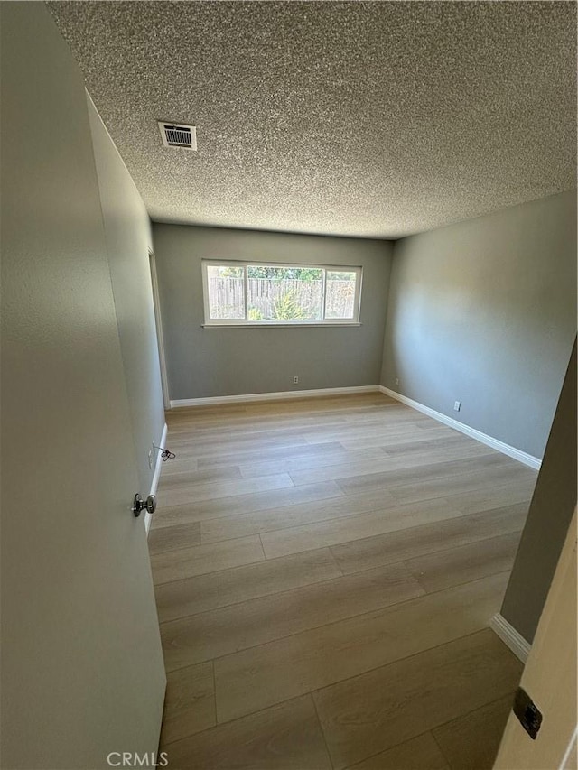 8567 Jasper St, Rancho Cucamonga, CA 91730 - spare room with light wood-style floors and a textured ceiling
