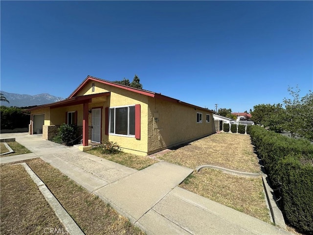 8567 Jasper St, Rancho Cucamonga, CA 91730 - view of front facade featuring stucco siding, an attached garage, concrete driveway, and a mountain view