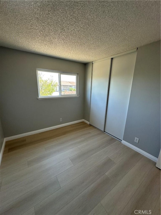 8567 Jasper St, Rancho Cucamonga, CA 91730 - unfurnished bedroom with light wood finished floors, a textured ceiling, and a closet