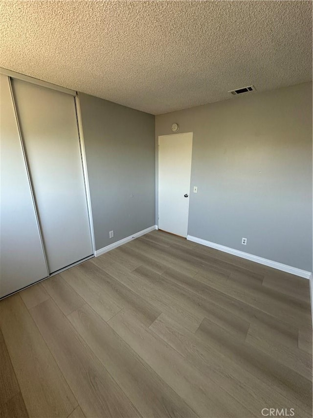 8567 Jasper St, Rancho Cucamonga, CA 91730 - unfurnished bedroom with wood finished floors, a closet, and a textured ceiling