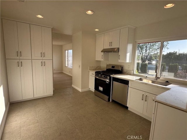8567 Jasper St, Rancho Cucamonga, CA 91730 - kitchen featuring appliances with stainless steel finishes, under cabinet range hood, plenty of natural light, white cabinetry, and recessed lighting
