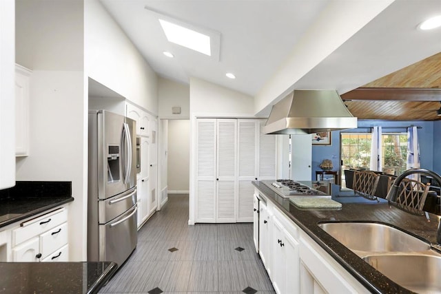 2045 W Clover Ave, Anaheim, CA 92801 - kitchen with appliances with stainless steel finishes, wall chimney exhaust hood, vaulted ceiling, white cabinetry, and dark stone countertops