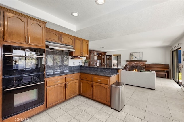22074 Cedardale Dr, Diamond Bar, CA 91765 - kitchen with under cabinet range hood, black appliances, a peninsula, brown cabinets, and light tile patterned floors