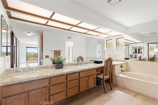 22074 Cedardale Dr, Diamond Bar, CA 91765 - bathroom featuring wood finished floors, a garden tub, and double vanity