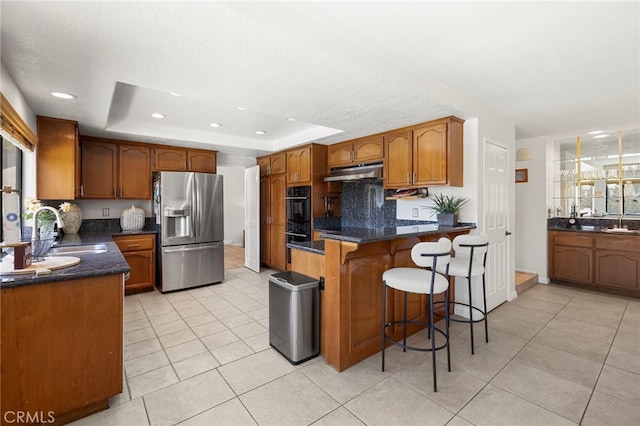 22074 Cedardale Dr, Diamond Bar, CA 91765 - kitchen featuring stainless steel fridge with ice dispenser, a raised ceiling, light tile patterned flooring, under cabinet range hood, and brown cabinets