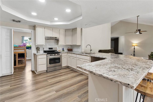 10325 Sheep Creek Rd, Phelan, CA 92371 - kitchen featuring stainless steel gas range, a peninsula, light wood-style floors, recessed lighting, and a kitchen breakfast bar