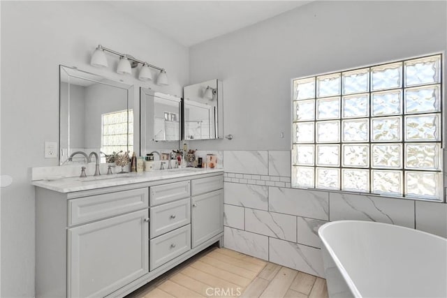 10325 Sheep Creek Rd, Phelan, CA 92371 - bathroom with double vanity, a freestanding tub, tile walls, and wood finished floors
