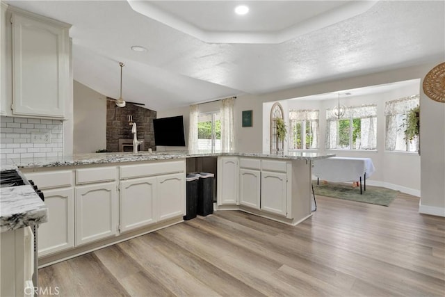 10325 Sheep Creek Rd, Phelan, CA 92371 - kitchen featuring a ceiling fan, light wood-type flooring, light stone countertops, hanging light fixtures, and vaulted ceiling