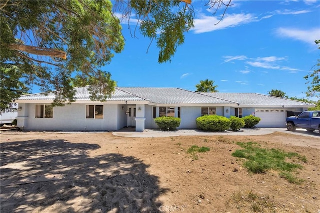 10325 Sheep Creek Rd, Phelan, CA 92371 - ranch-style home with a tiled roof, a garage, and stucco siding