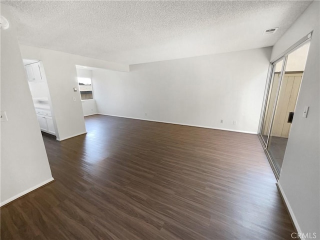 1815 W 145th St Unit 9, Gardena, CA 90249 - unfurnished living room featuring dark wood-style floors and a textured ceiling