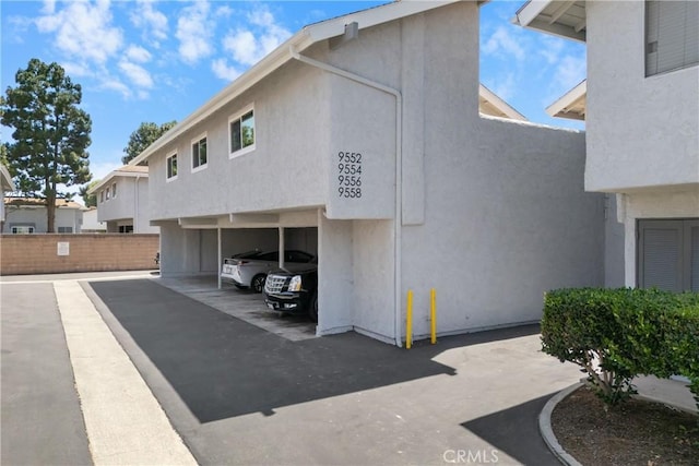 9554 Bickley Dr Unit 8, Huntington Beach, CA 92646 - view of home's exterior with stucco siding and covered parking