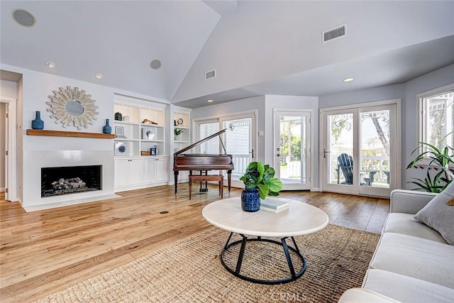 1310 Gates Ave, Manhattan Beach, CA 90266 - living room featuring wood finished floors, high vaulted ceiling, a fireplace with flush hearth, and built in shelves