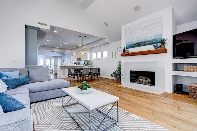 1310 Gates Ave, Manhattan Beach, CA 90266 - living area with healthy amount of natural light, wood finished floors, high vaulted ceiling, a fireplace with flush hearth, and recessed lighting