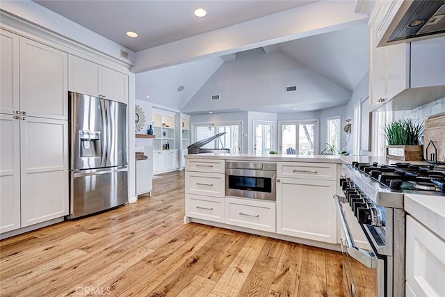 1310 Gates Ave, Manhattan Beach, CA 90266 - kitchen with stainless steel appliances, range hood, a peninsula, light wood-style flooring, and white cabinets