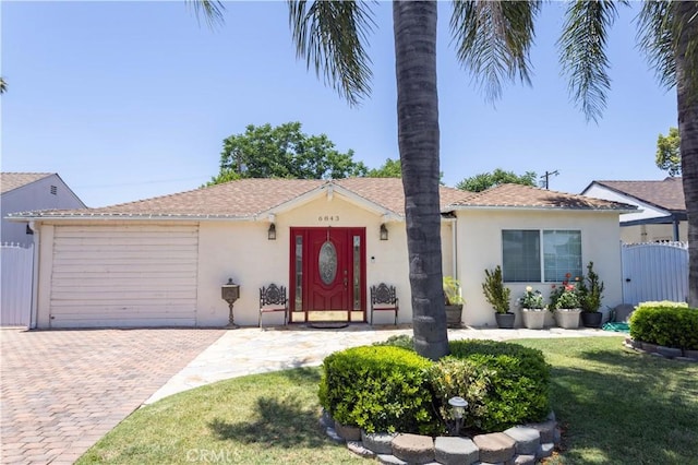 6843 Penfield Ave, Winnetka, CA 91306 - ranch-style house featuring decorative driveway, a garage, stucco siding, and a gate