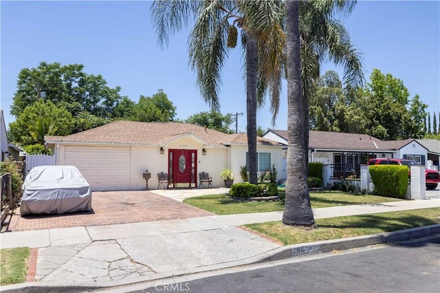 6843 Penfield Ave, Winnetka, CA 91306 - ranch-style home with decorative driveway, an attached garage, and a front yard