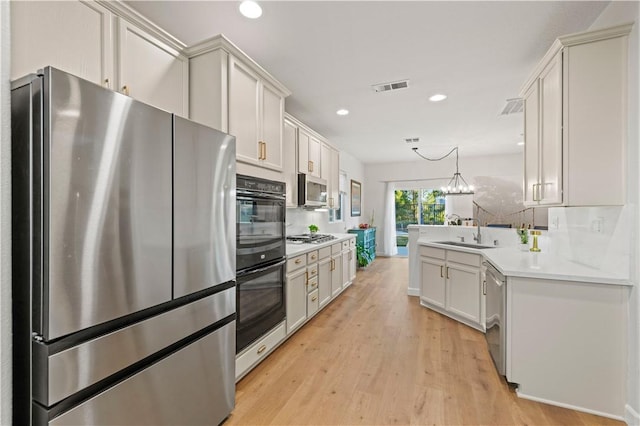 28238 Alton Way, Castaic, CA 91384 - kitchen featuring stainless steel appliances, light wood finished floors, light countertops, recessed lighting, and decorative light fixtures
