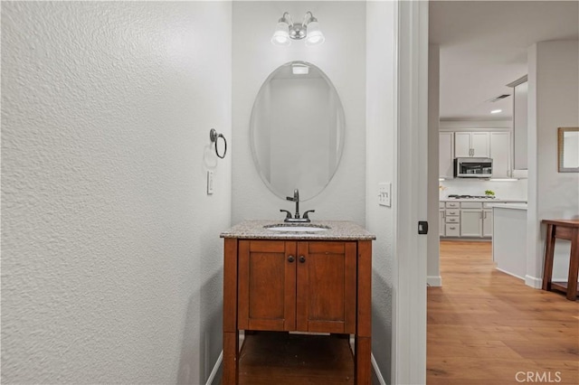 28238 Alton Way, Castaic, CA 91384 - bathroom with wood finished floors, vanity, a textured wall, and recessed lighting