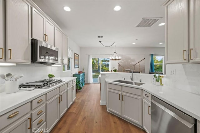 28238 Alton Way, Castaic, CA 91384 - kitchen featuring stainless steel appliances, recessed lighting, a peninsula, light countertops, and wood finished floors