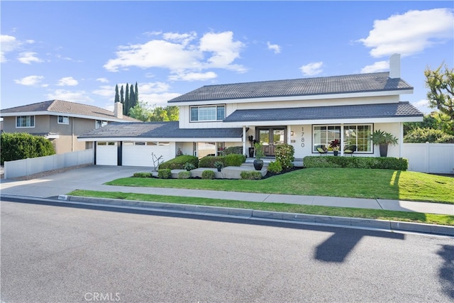 1780 N Mockingbird Pl, Orange, CA 92867 - view of front facade featuring a chimney, a garage, concrete driveway, a tile roof, and a porch