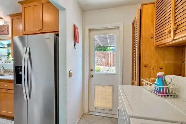 826 Laurelwood Ct, San Marcos, CA 92069 - kitchen with stainless steel fridge with ice dispenser, separate washer and dryer, light tile patterned floors, light countertops, and brown cabinetry