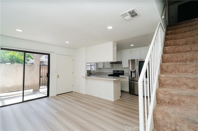 1438 W 146th St Unit 6, Gardena, CA 90247 - kitchen with stainless steel fridge with ice dispenser, black range with electric cooktop, a peninsula, light wood finished floors, and light countertops