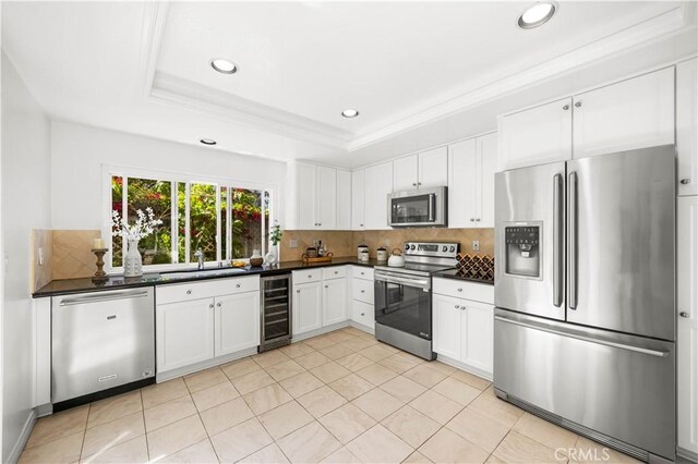 18701 Paseo Cortez, Irvine, CA 92603 - kitchen featuring appliances with stainless steel finishes, wine cooler, decorative backsplash, dark countertops, and recessed lighting