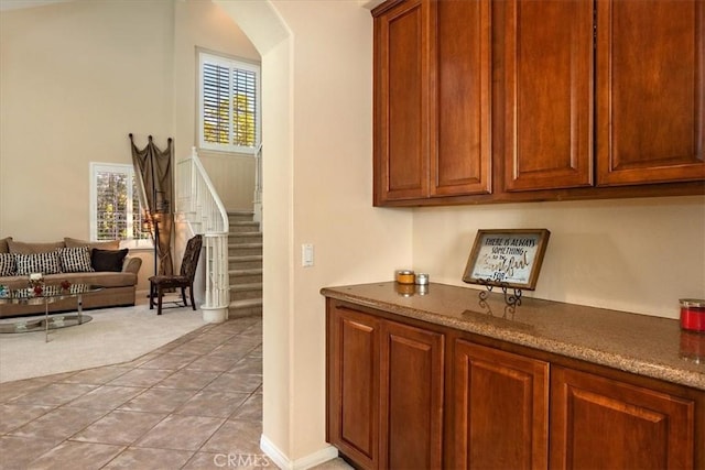 12487 Altura Dr, Rancho Cucamonga, CA 91739 - bar area with stairs, light colored carpet, and arched walkways