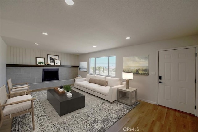 27825 Beryl Rd, Barstow, CA 92311 - living room featuring wood finished floors, a tiled fireplace, and recessed lighting
