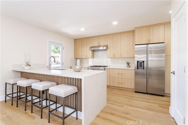 20611 Devonshire St, Chatsworth, CA 91311 - kitchen with stainless steel fridge, light brown cabinets, extractor fan, a kitchen breakfast bar, and recessed lighting