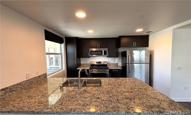 612 E Carson St Unit 303, Carson, CA 90745 - kitchen with appliances with stainless steel finishes, stone counters, a peninsula, recessed lighting, and dark brown cabinets