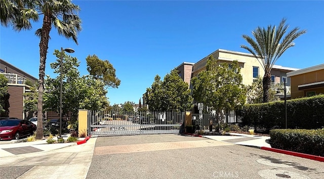 612 E Carson St Unit 303, Carson, CA 90745 - view of asphalt road with curbs, a gate, street lights, and a gated entry