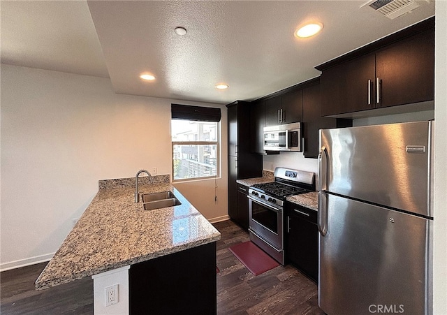 612 E Carson St Unit 303, Carson, CA 90745 - kitchen with stainless steel appliances, dark wood finished floors, a peninsula, recessed lighting, and light stone counters