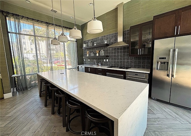 612 E Carson St Unit 303, Carson, CA 90745 - kitchen featuring appliances with stainless steel finishes, decorative backsplash, glass insert cabinets, dark brown cabinetry, and a kitchen island
