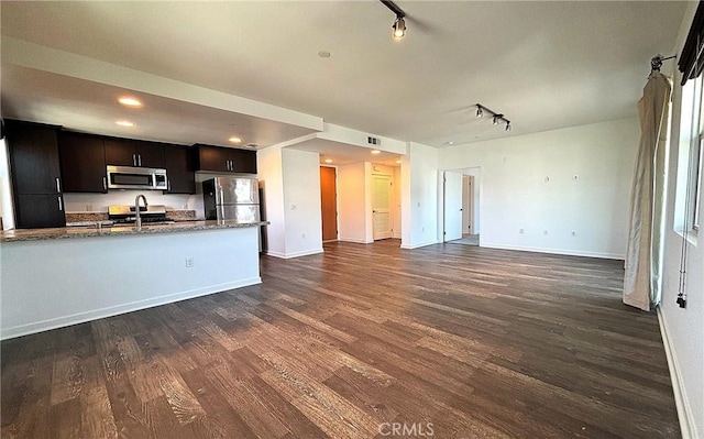 612 E Carson St Unit 303, Carson, CA 90745 - kitchen with stainless steel appliances, rail lighting, open floor plan, dark wood-style floors, and stone countertops